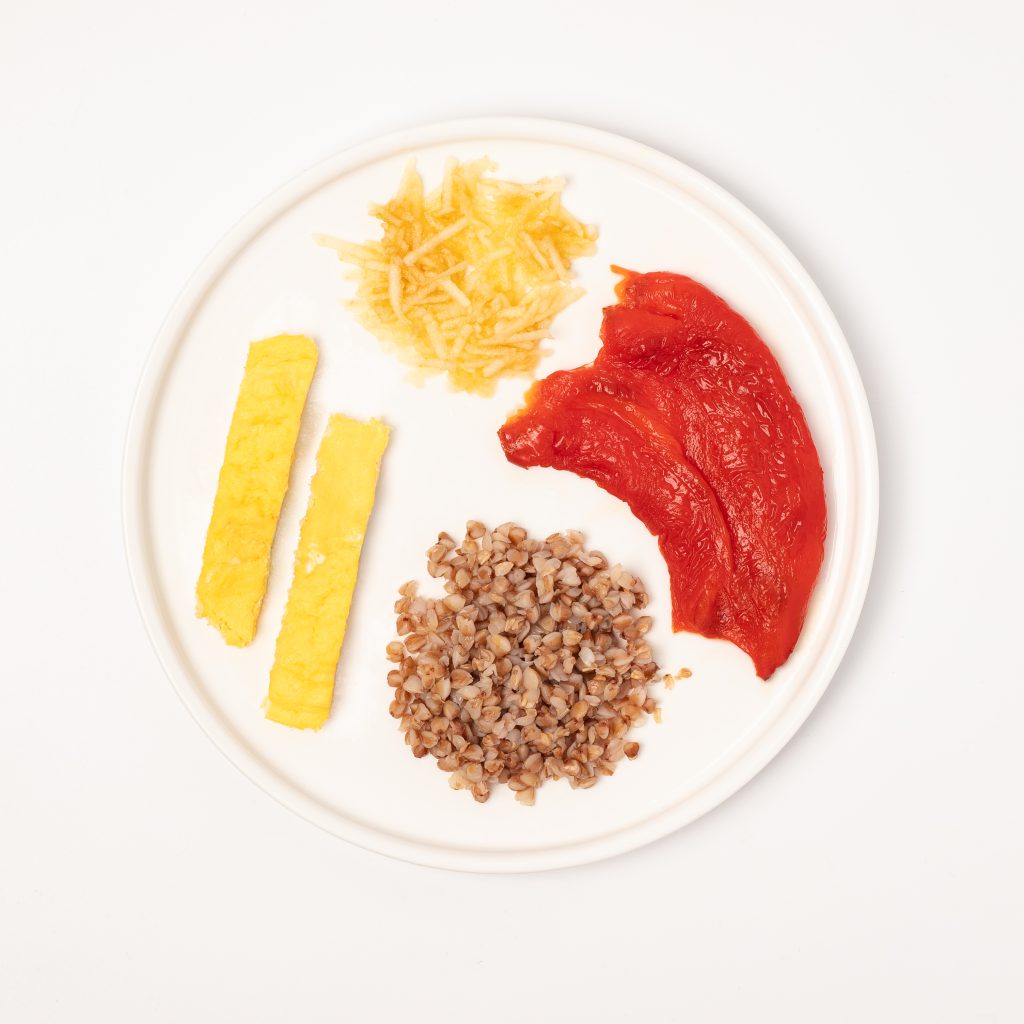 BLW-style lunch for a child: buckwheat, omelette sticks, stewed bell pepper, and grated apple